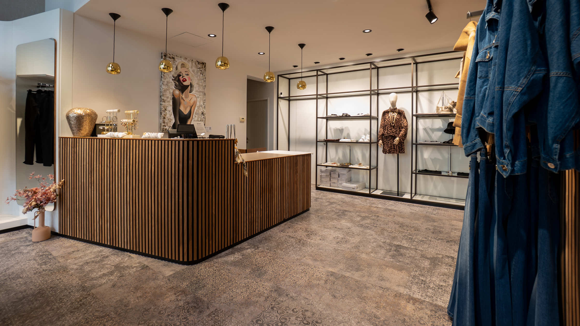 Kassenbereich der LIMAA Boutique in Baden mit holzverkleidetem Tresen, Schmuckauslage und einem großformatigen Marilyn-Monroe-Porträt